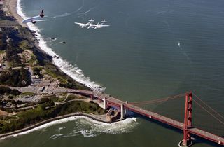 Virgin Galactic's private SpaceShipTwo spacecraft and its mothership WhiteKnightTwo flies over the Golden Gate Bridge with the Virgin America plane "My Other Ride is a Spaceship" on April 6, 2011 en route to open Terminal 2 at San Francisco International 