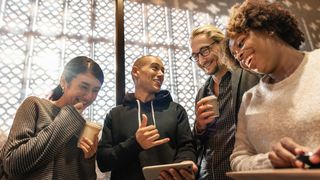 Image of four people talking and looking at a tablet screen