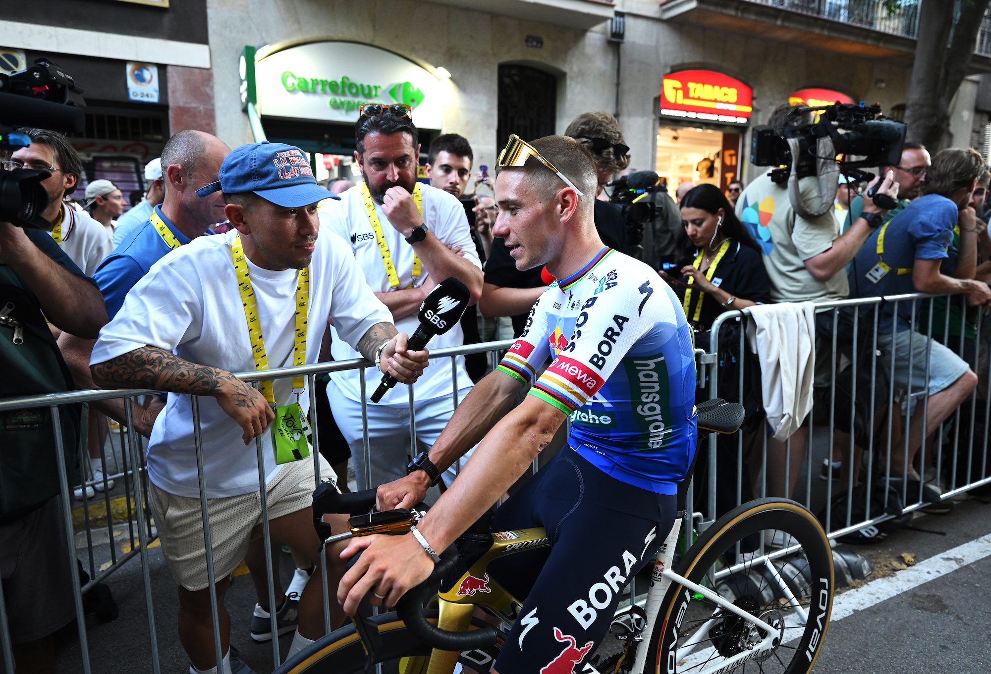 Ex pro-rider, Caleb Ewan of Australia, interviews Remco Evenepoel of Red Bull - BORA - hansgrohe during the team presentation of 2026 Tour de France