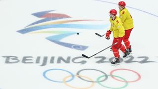 Ice hockey players preparing on the ice at the 2022 Winter Olympics