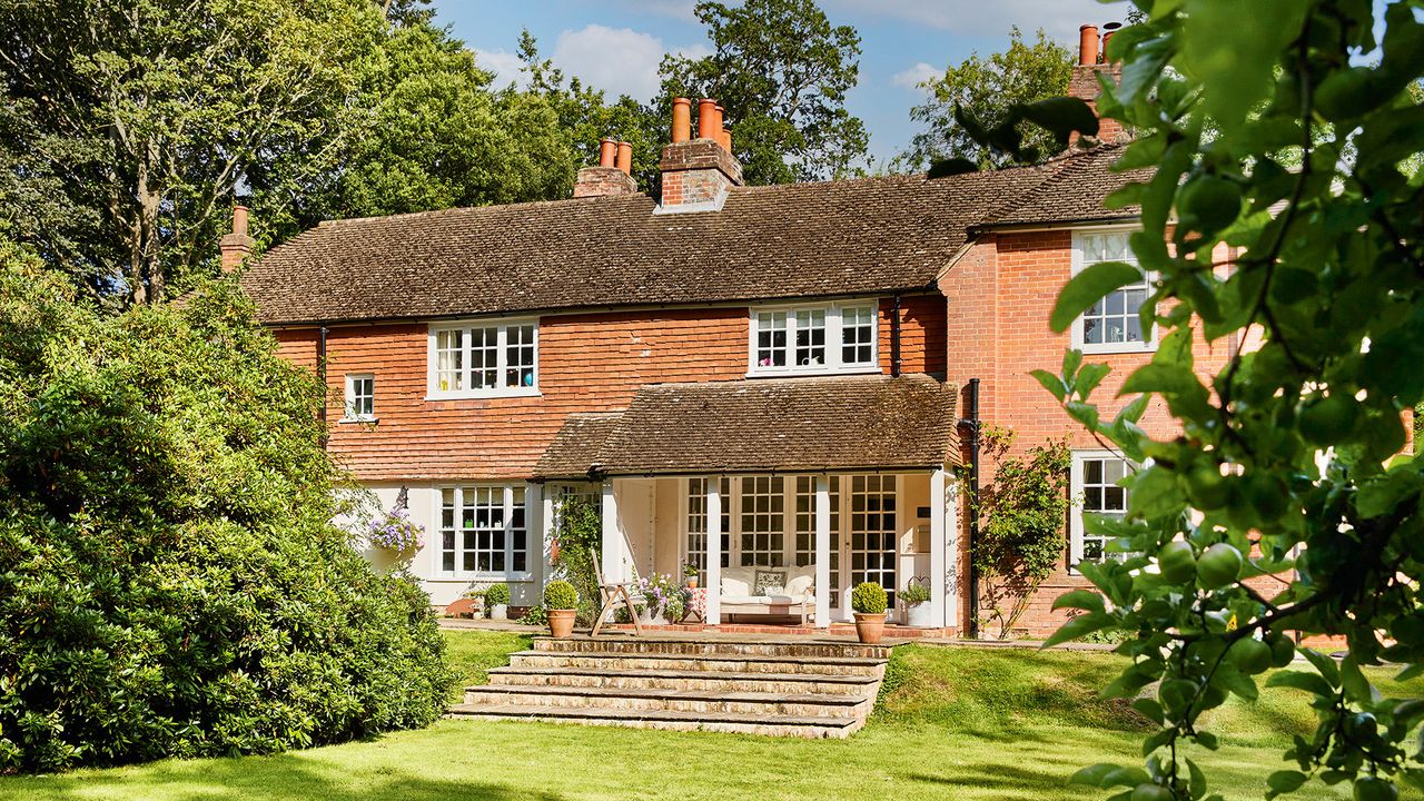 Restored 18th century farmhouse in summer with blue skies winner of Period Living home of the year 2021