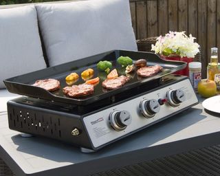 Royal Gourmet Portable 3-Burner Table Top Gas Grill Griddle being used on outdoor surface