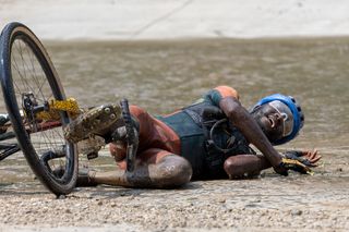 A rider crashes in a water crossing at the 2023 Unbound Gravel race