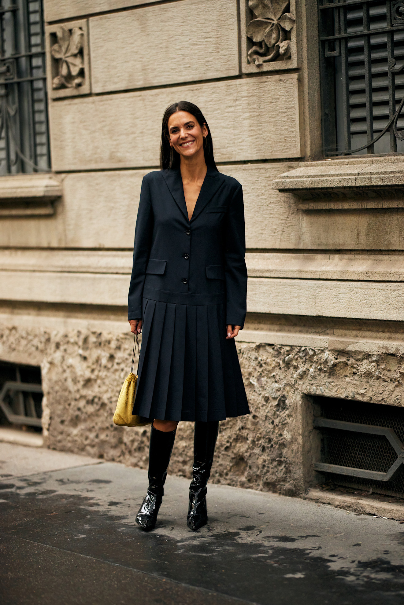 Woman in blazer dress with knee-high boots.