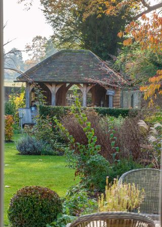 garden building gazebo in a garden with autumnal plants and foliage