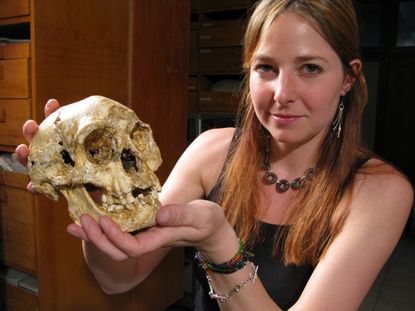Alice Roberts, of the University of Birmingham, holds the skull of a hobbit, or <em>Homo floresiensis</em>.