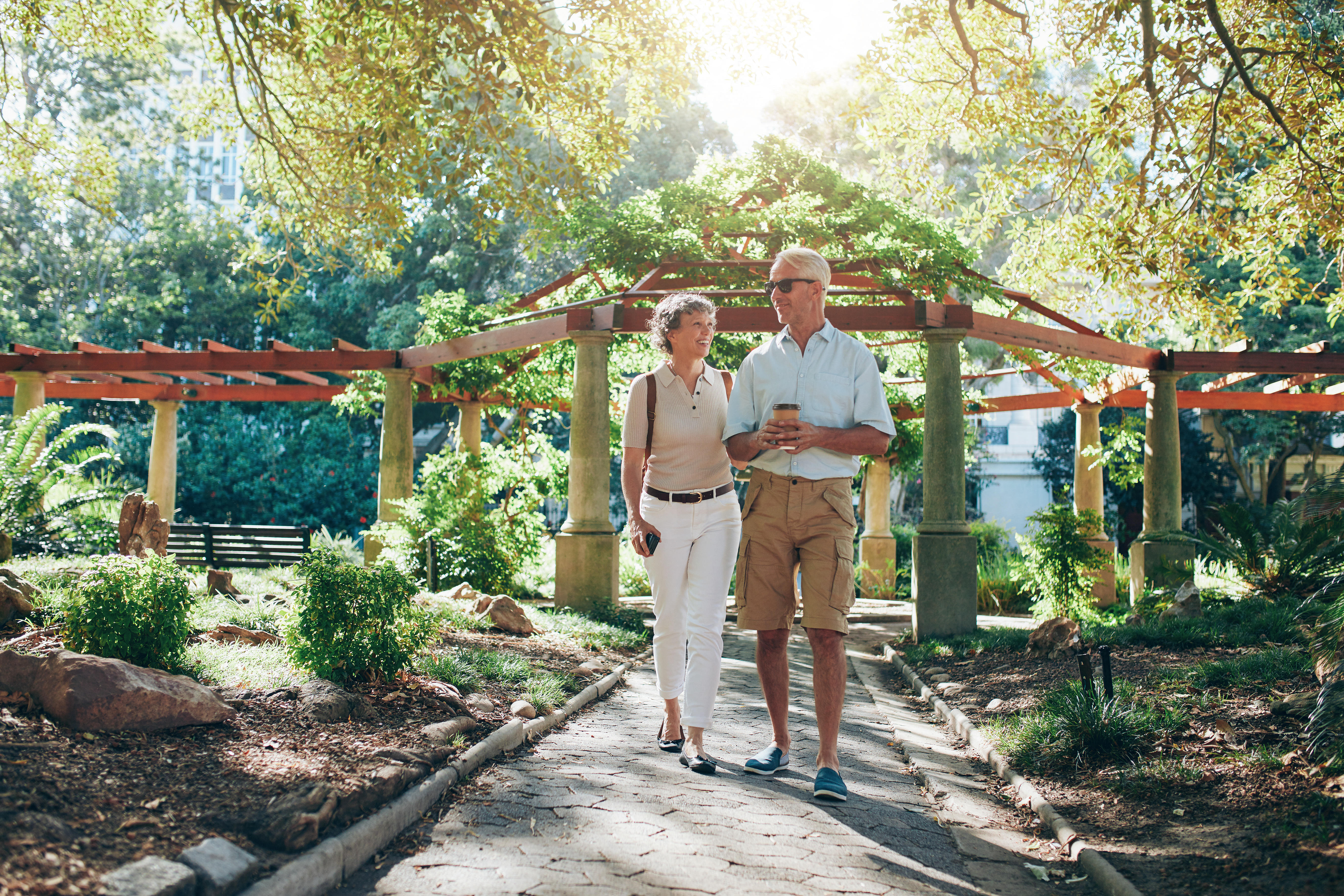GEW03B Full length portrait of happy senior couple walking together in a city park. Mature man and woman on a vacation.