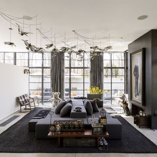 living area with grey sofa and back rug