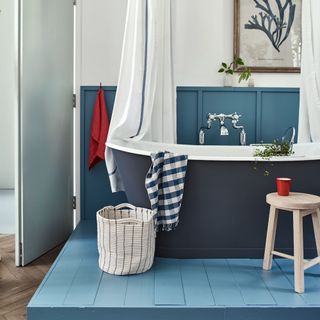 A bathroom with a bathtub and pops of red