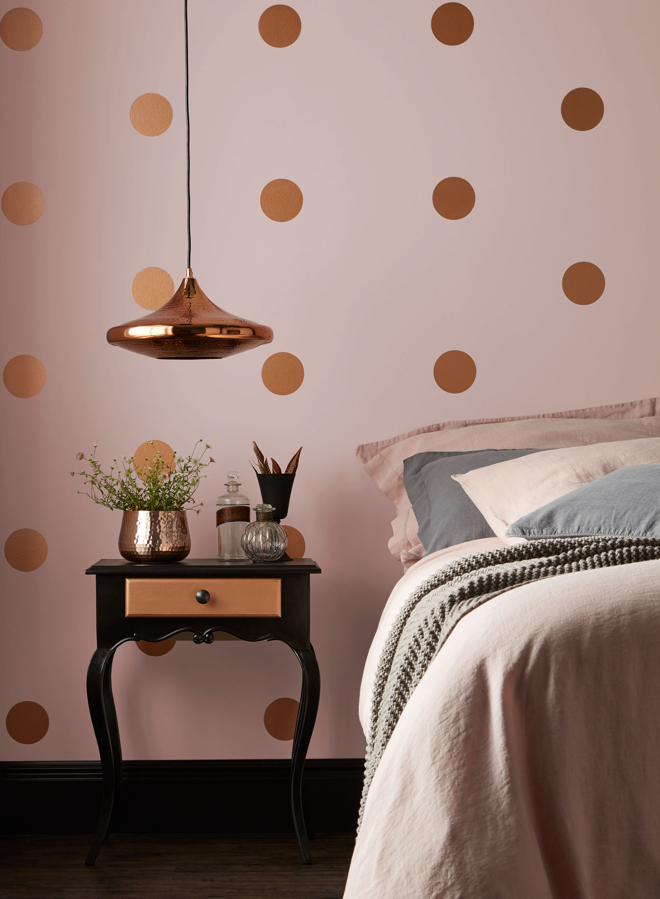 A pink bedroom with walls painted in Pashmina with copper spots by Crown
