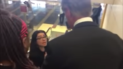 Protesters on escalator with David Perdue.