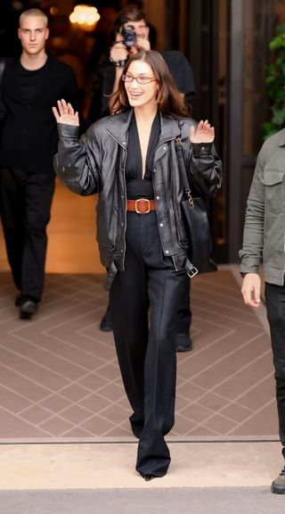 Bella Hadid wears a leather aviator jacket with a jumpsuit at Paris Fashion Week