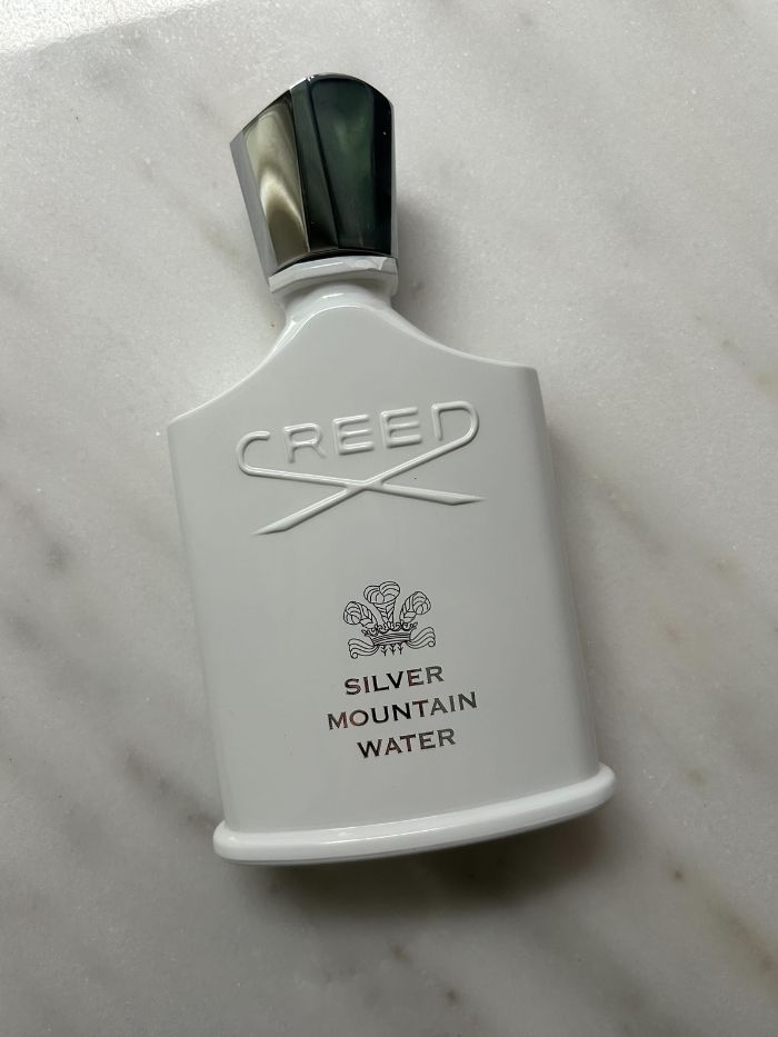 A picture of a Creed perfume on a marble background