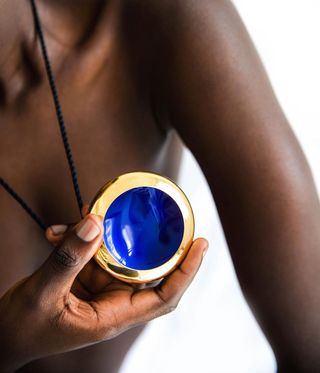 Woman holding a blue pendant