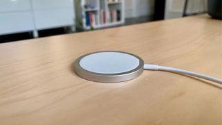 An Apple MagSafe charger on a desk.