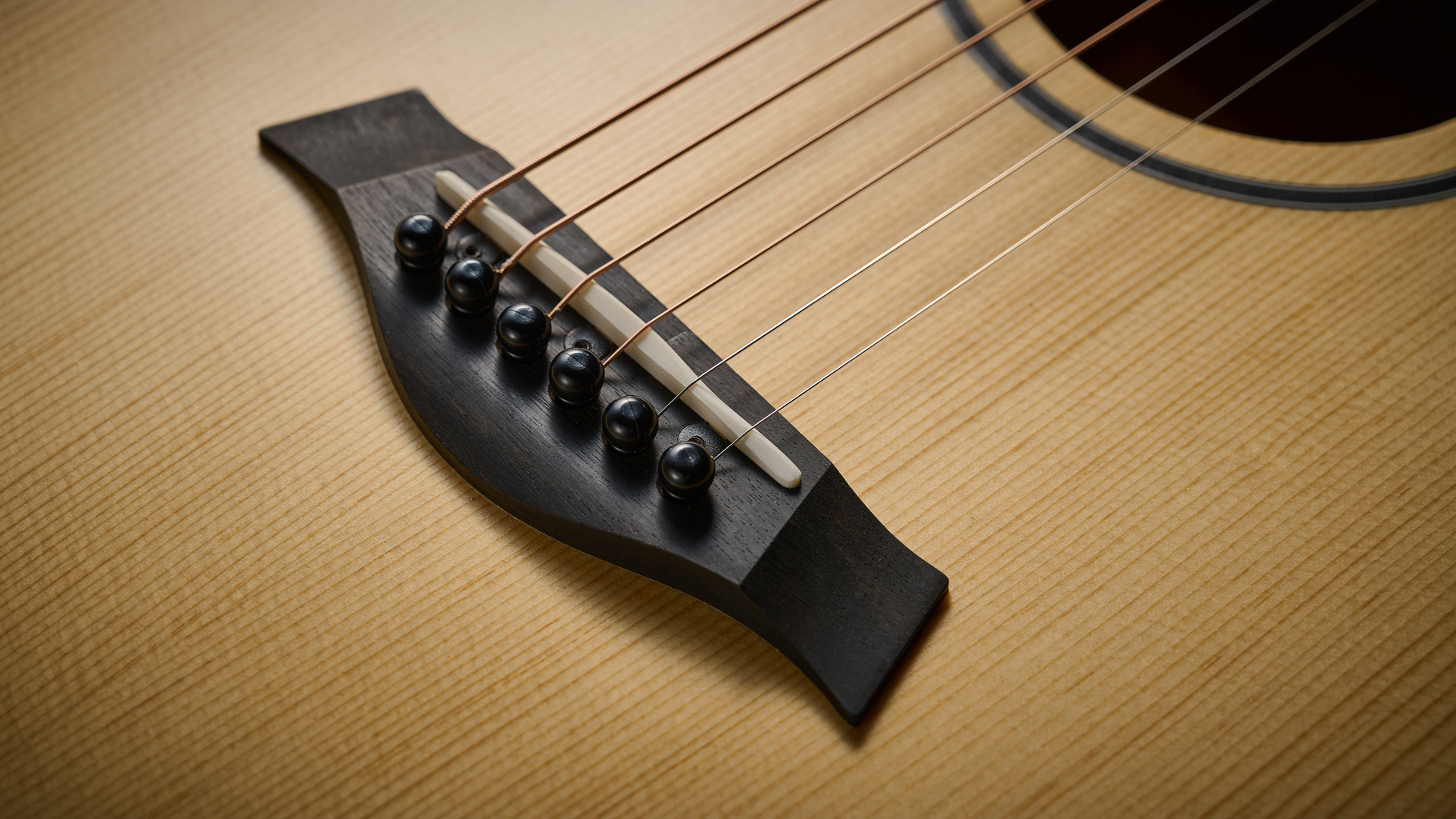 Close up of the bridge on the Taylor BT1e Baby Taylor 3/4 acoustic guitar