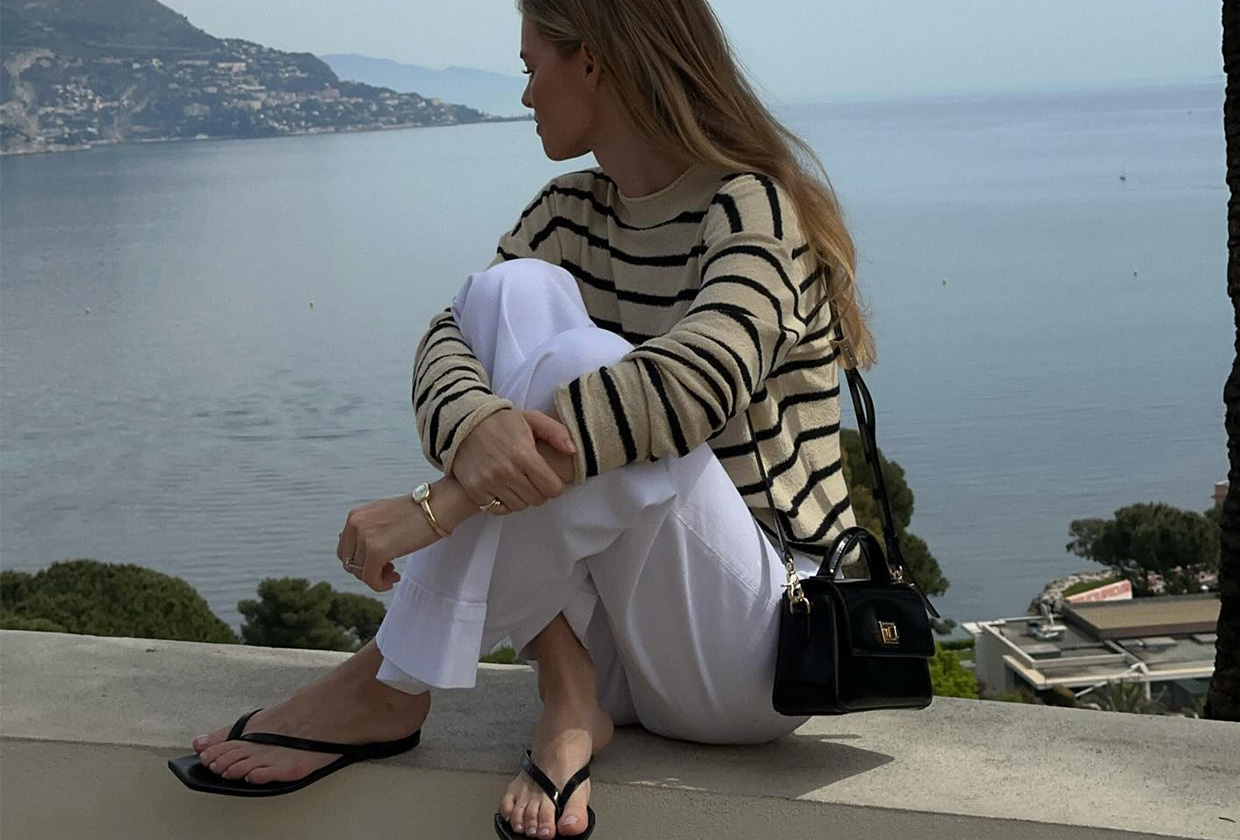 Claire Rose wears Toteme flip-flops and a striped sweater