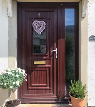 front door with wooden door and flower pot