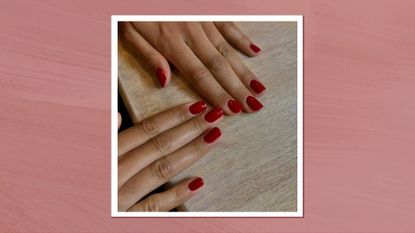 A close-up of two hands with short, red 'cranberry'-style nails by nail artist @gel.bymegan/ in a dark pink template