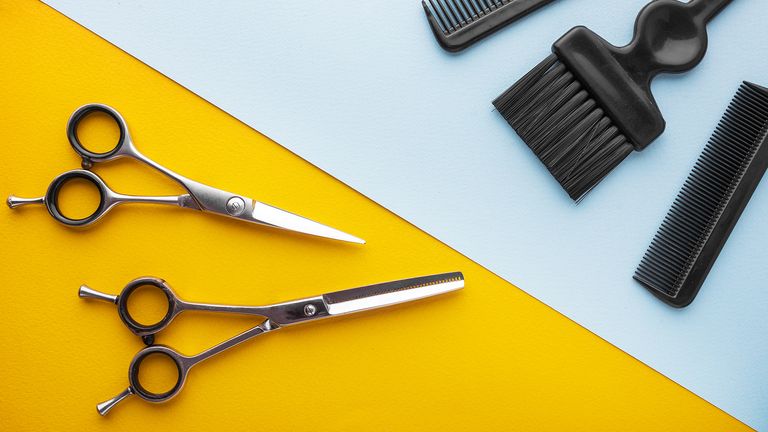 hairdressing scissors and tools on blue and yellow backdrop