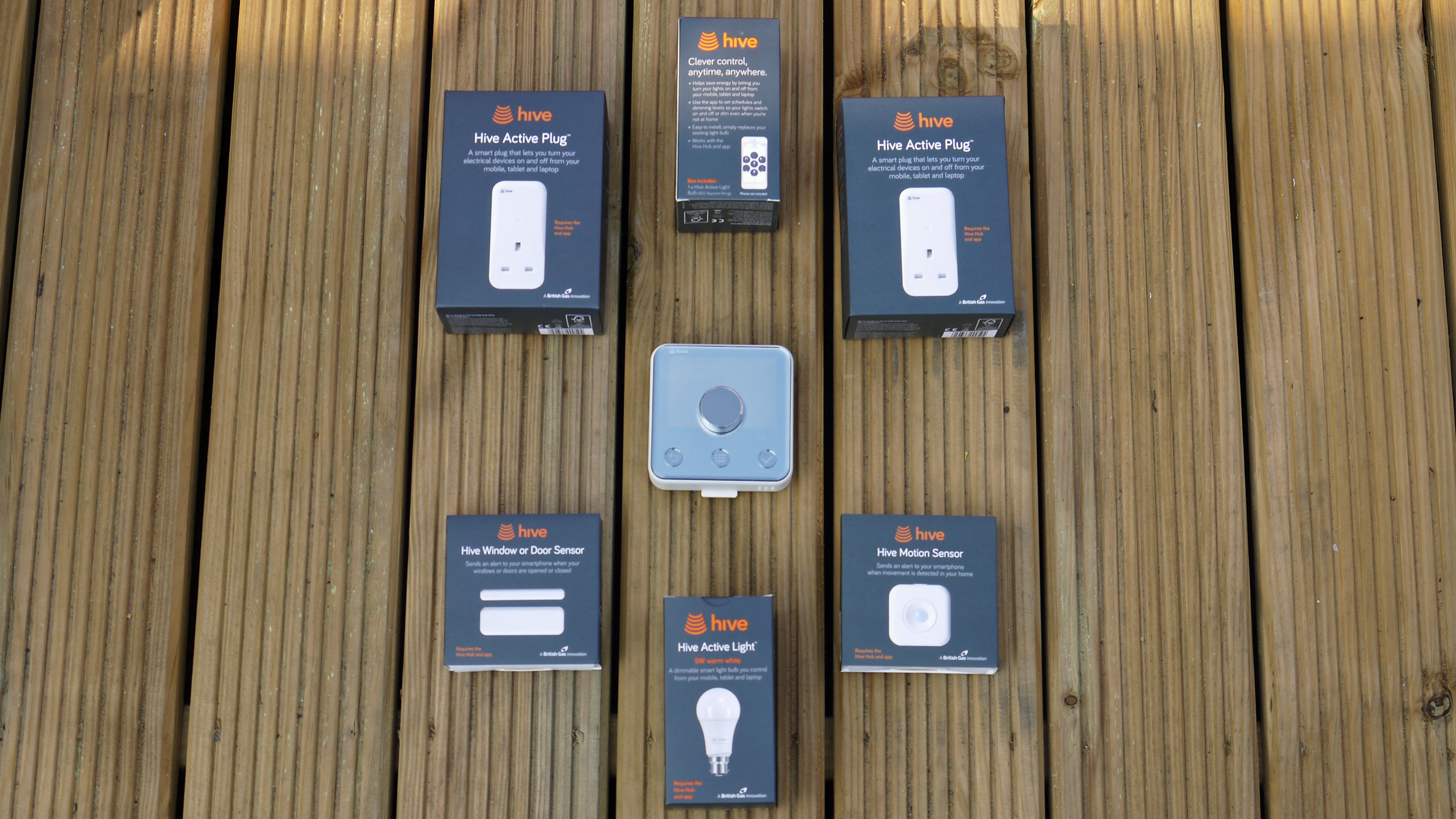 The Hive thermostat surrounded by several smart home gadgets including smart lights and plugs
