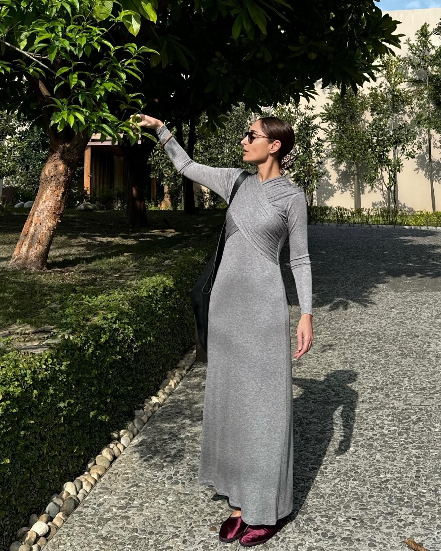 Influenciadora francesa usando um vestido longo cinza e sapatos bordô