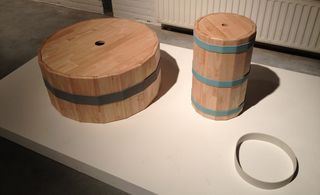 Two wooden barrels coffee tables. One is wider and shorter, the other one is narrower and taller.