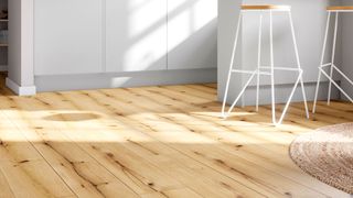 Light wood effect vinyl planks in a white kitchen with contemporary tall stools and a rug in shot