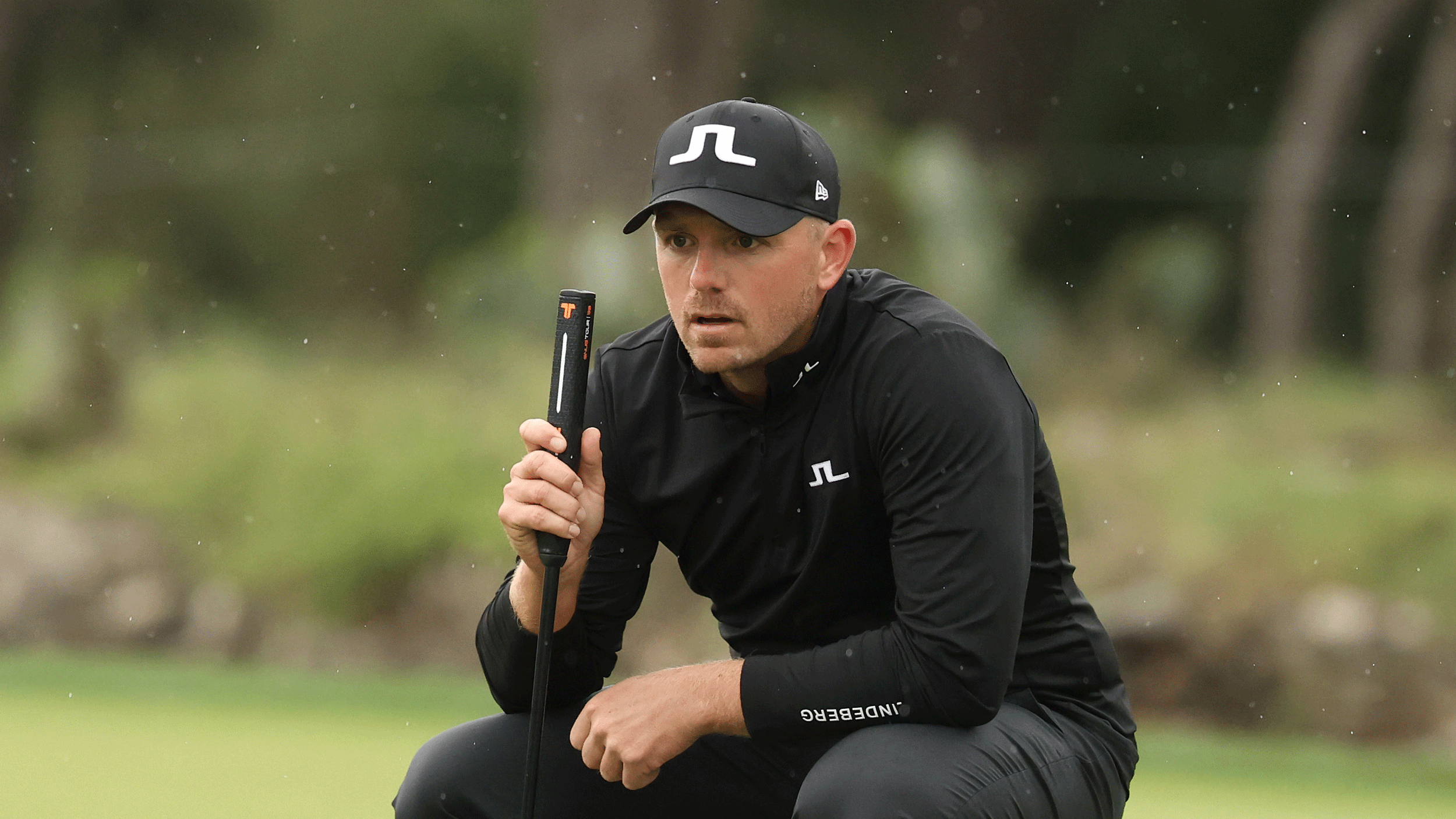 Matt Wallace crouches down behind a putt during the final round of the 2026 Valero Texas Open as the rain falls