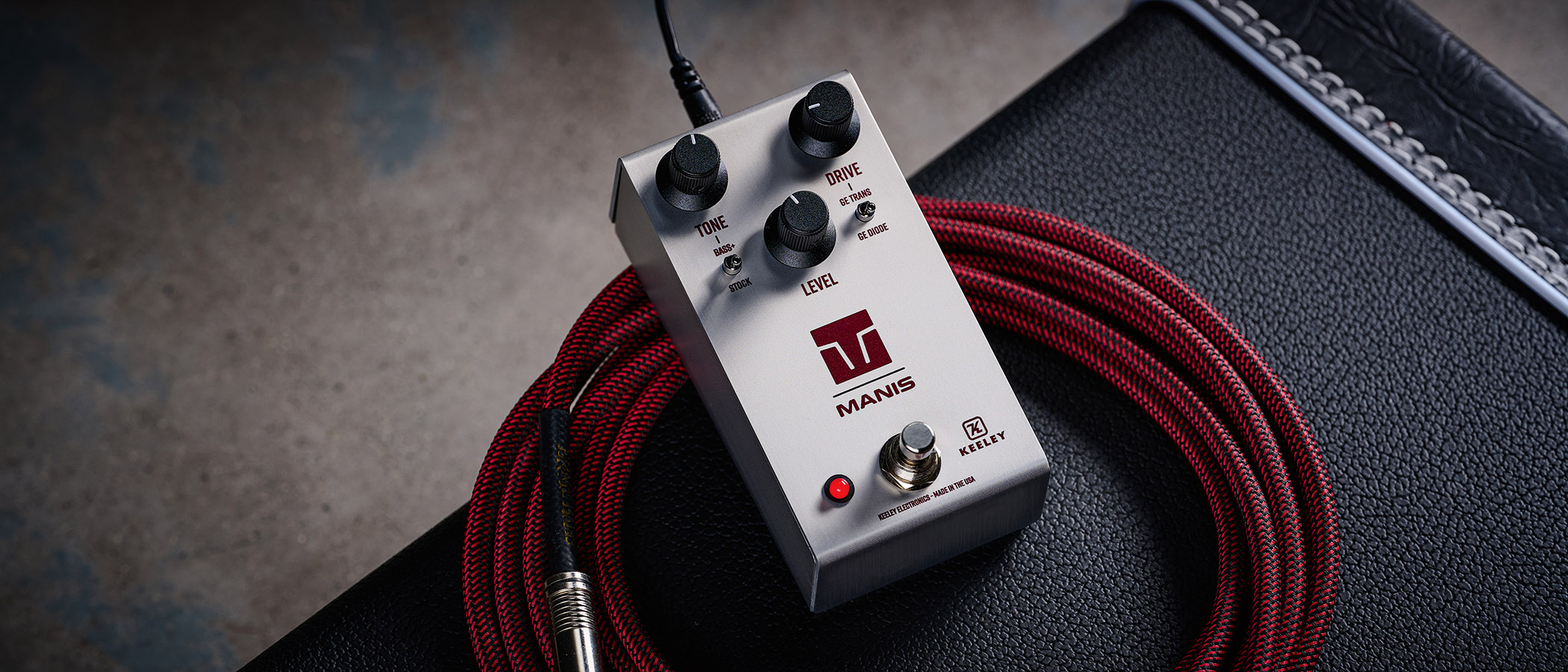 Keeley Electronics Manis: this ingenuous twist ont he K-style overdrive has three-knobs, a couple of mode switches, a tidy white finish and is photographed here against an amp with a red guitar cable.