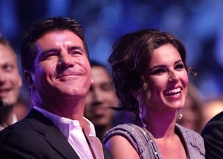 Simon Cowell and Cheryl Fernandez-Versini sit together at an awards show