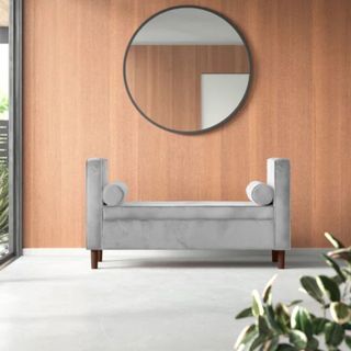 AllModern Kaj Storage Bench in grey with colster cushions against wooden wall with round mirror hanging above