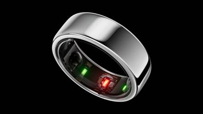 A close up of the Oura ring on a black background