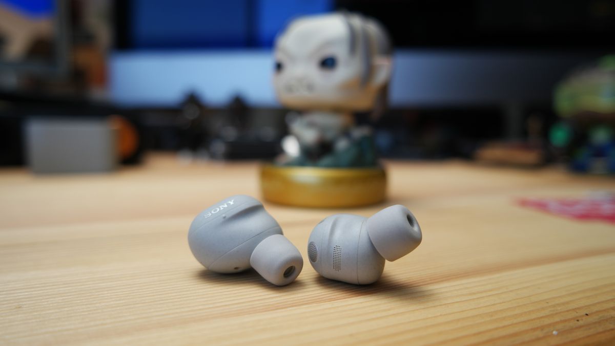 Sony WF-1000XM6 ANC earbuds sitting on a desk, in front of a Funko Pop of the character Gollum from the LOTR Trilogy