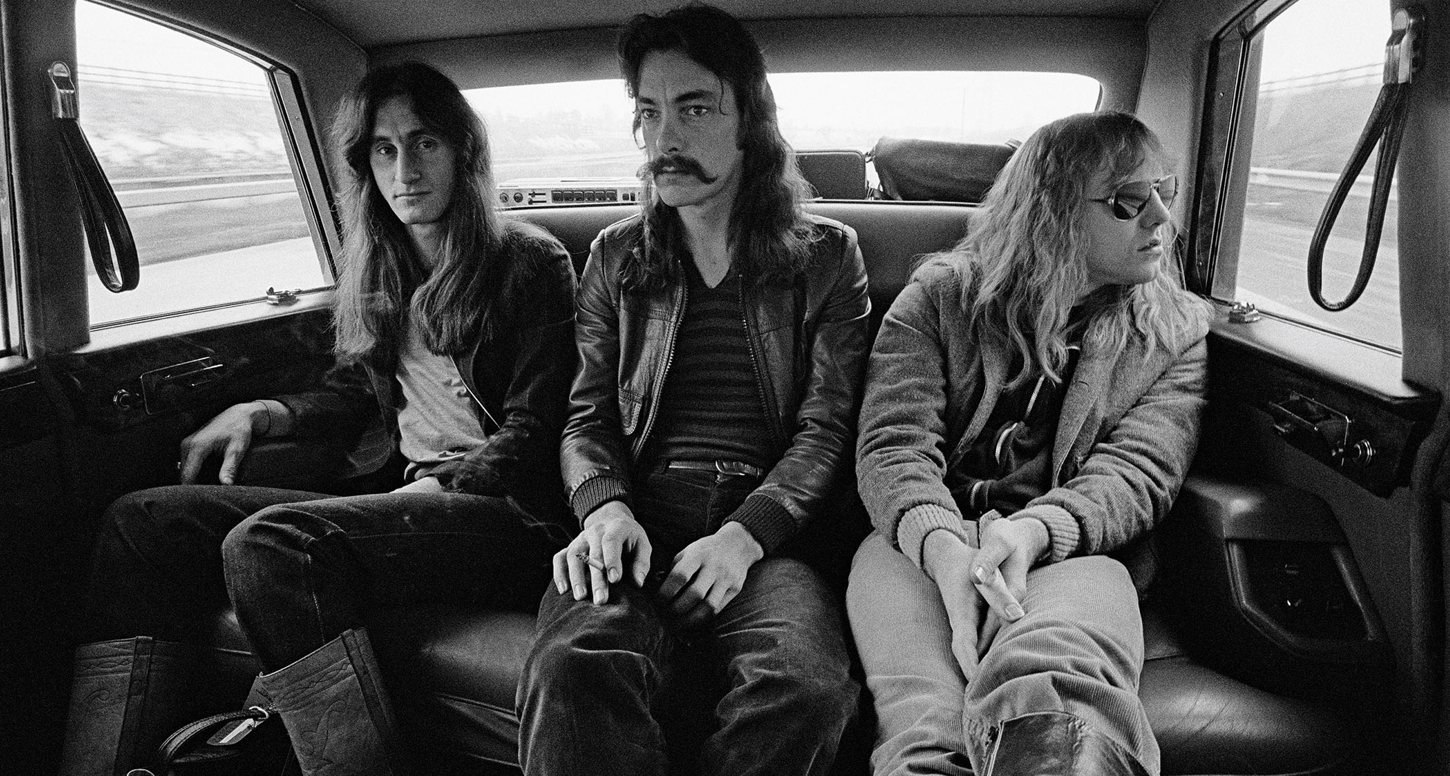 Rush get driven to a gig in Birmingham during their 1978 Farewell To Kings Tour: [from LEFT] bassist Geddy Lee, drummer Neil Peart and guitarist Alex Lifeson.