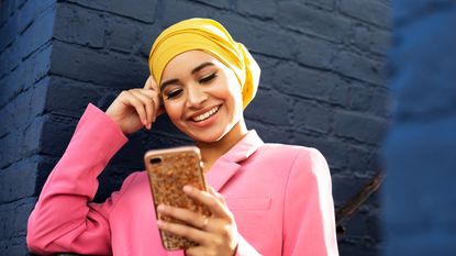 Young Muslim woman using phone