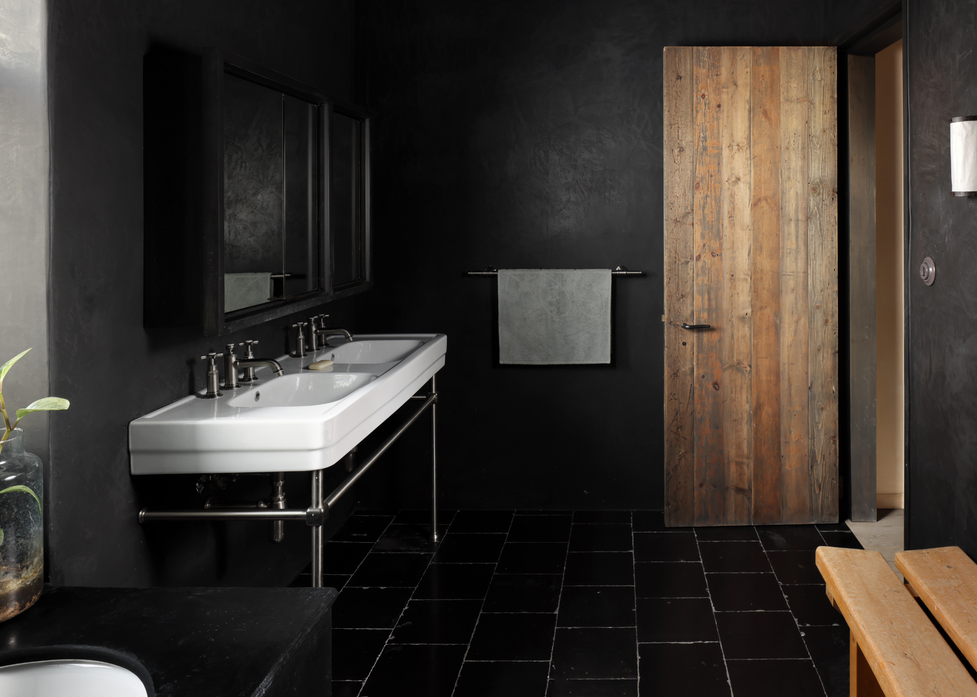 all black bathroom with double sink and wooden doors