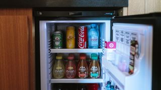 Open mini fridge stocked with beverages