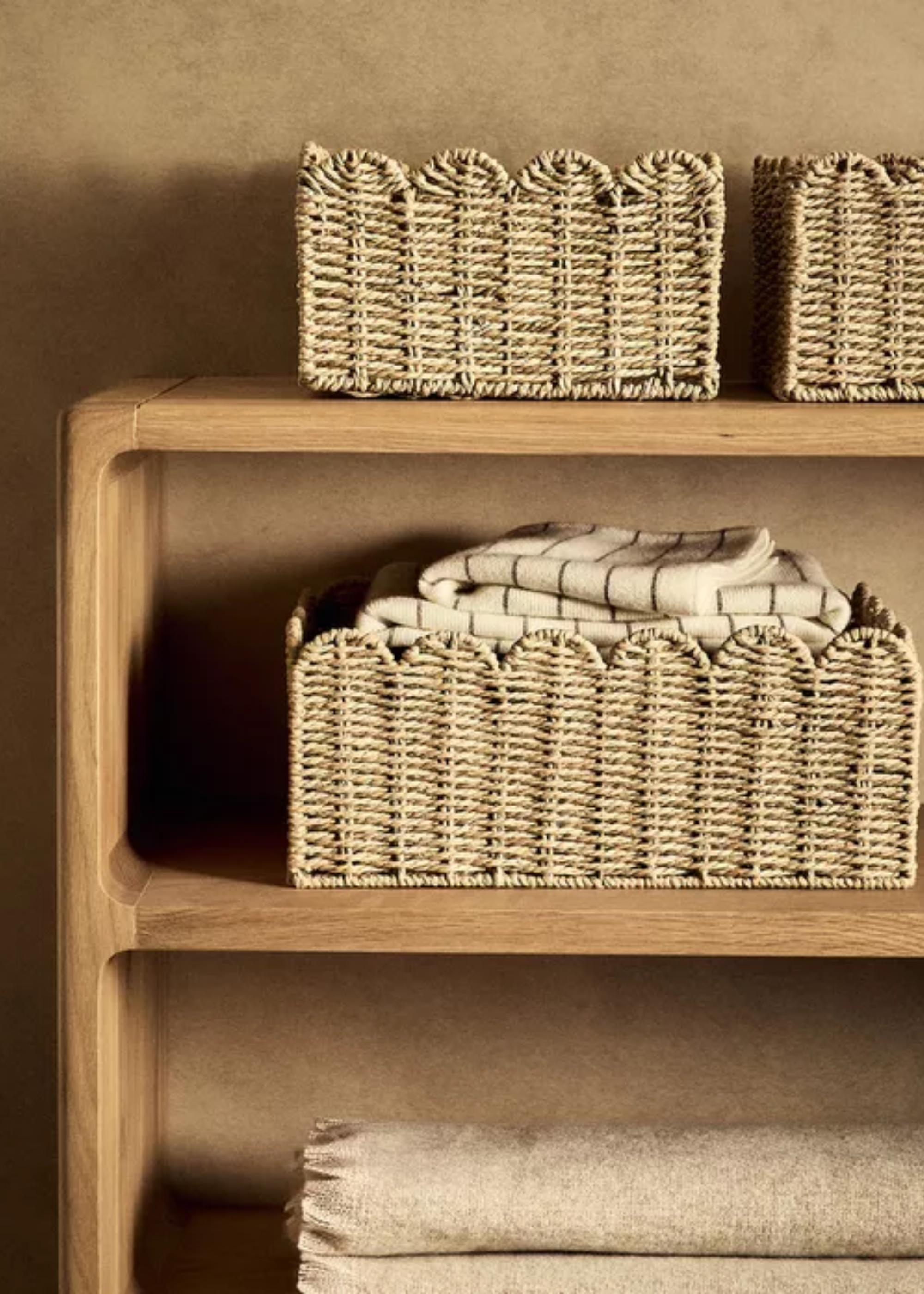 A wooden shelf with scalloped rattan baskets