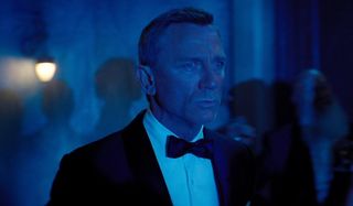 No Time To Die James Bond looks worried in a blue lit setting