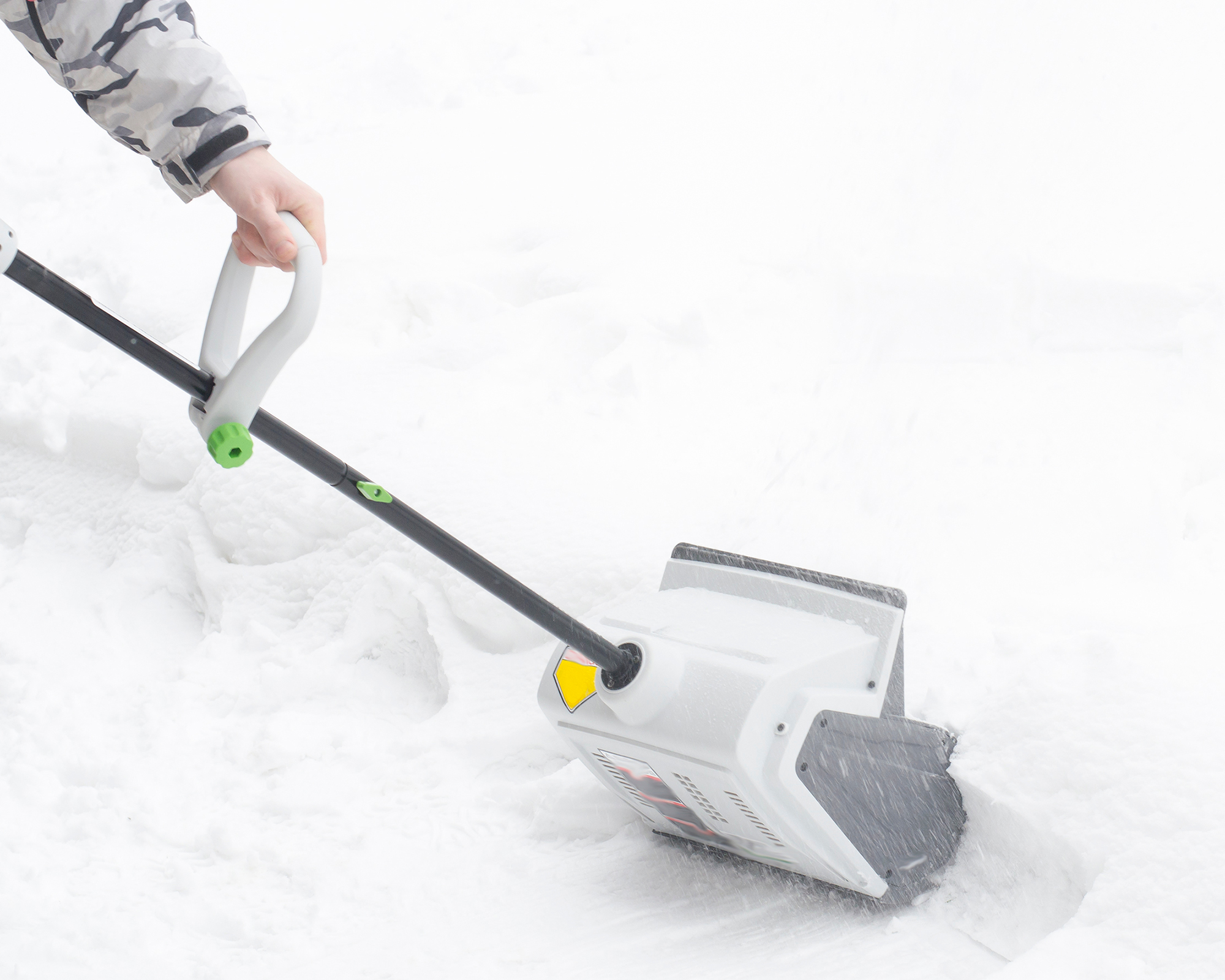 Gardener uses electric cordless snow shovel to clear snow