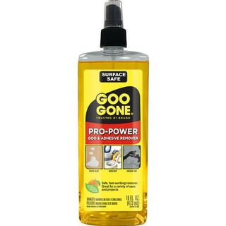 A clear bottle of Goo Gone Pro-Power Adhesive with yellow label and black lid