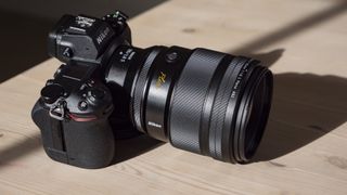 Nikon Z 135mm f/1.8 S Plena lens on a wooden table attached to Z6 II