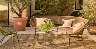 garden terrace with woven outdoor sofa and coffee table