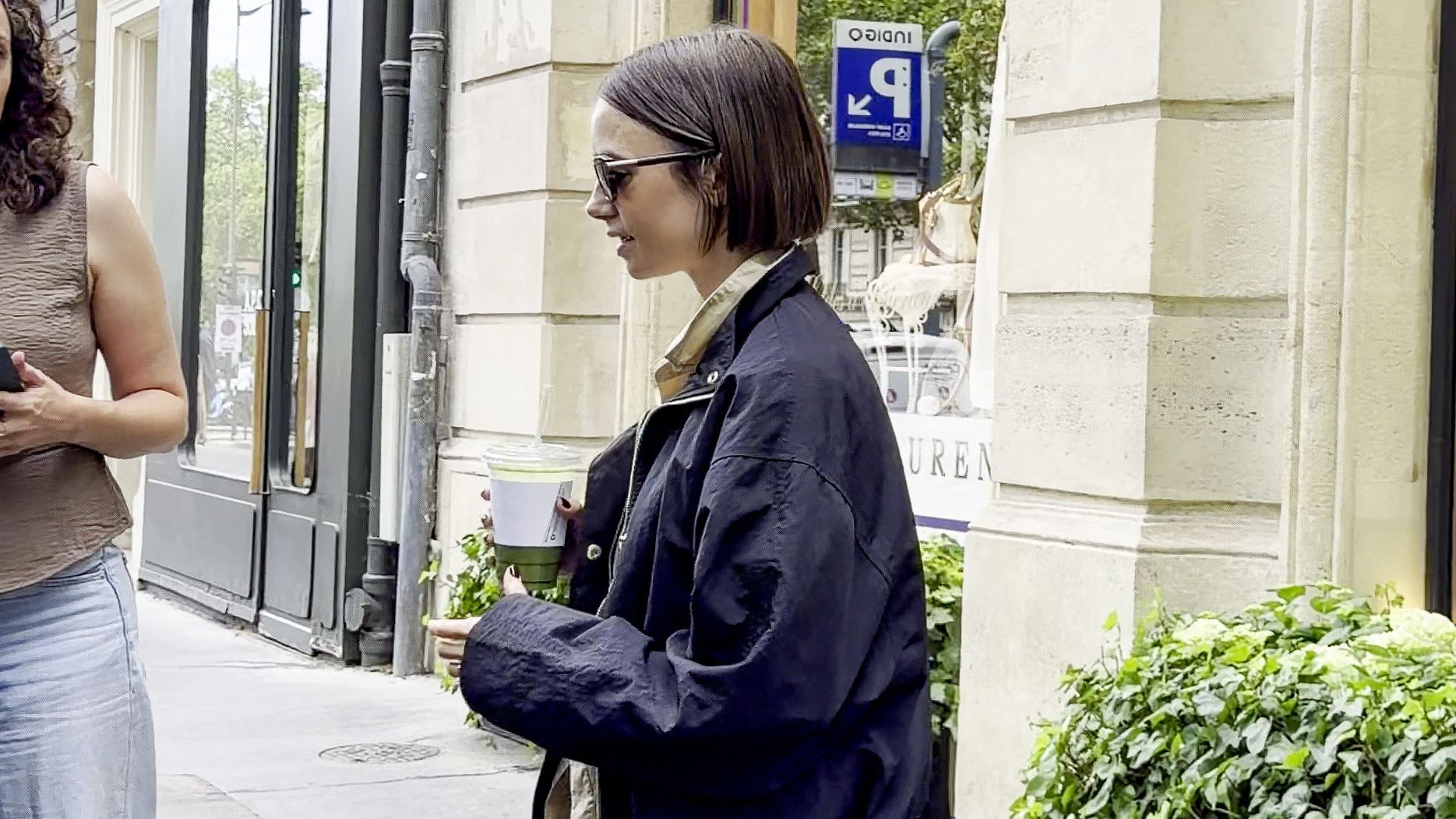 An image of Lily Collins wearing capri leggings and a white ballet flats. 