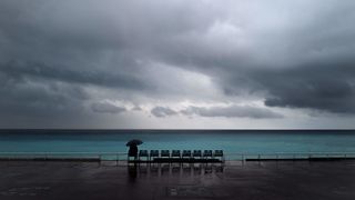 A man looks out into the Mediterranean sea on the in the French riviera city of Nice