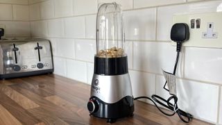 Nutribullet Magic Bullet Kitchen Express on a kitchen countertop filled with nuts ready to blend