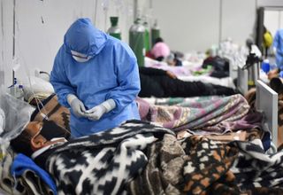 A health worker speaks with a patient at the Covid-19 specialized ward at the Honorio Delgado Hospital in Arequipa, Peru, on June 18, 2021.