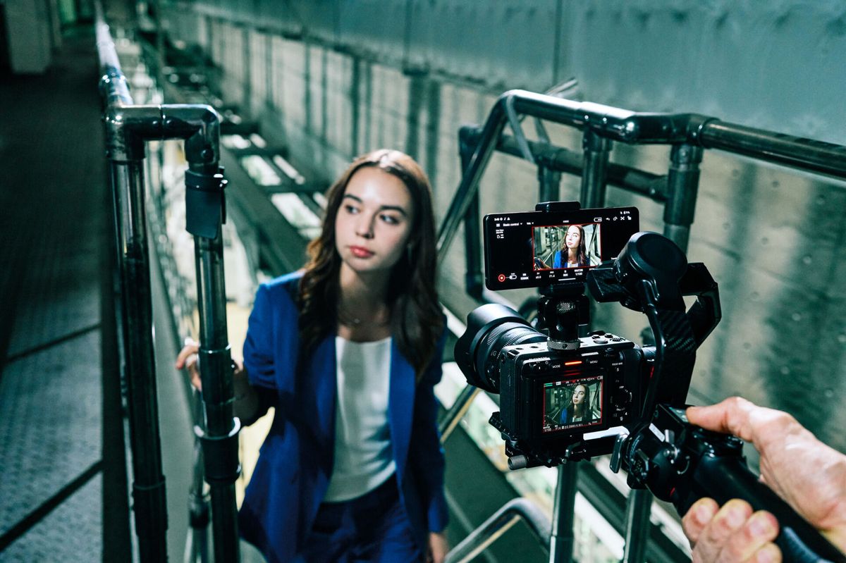 Smartphone attached to Sony cine camera and displaying Sony Monitor &amp; Control app with human subject in the frame