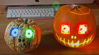 Two Halloween pumpkins, their eyes shining